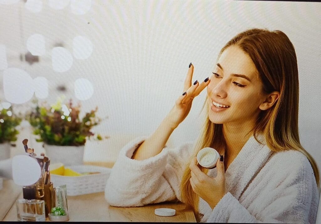 a woman applying moisturizer to her face