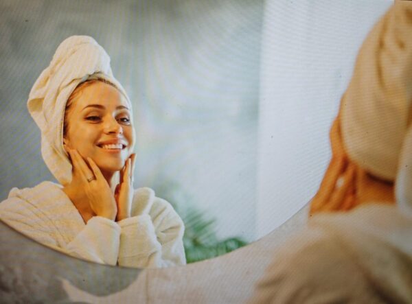 woman looking at her face in a mirror