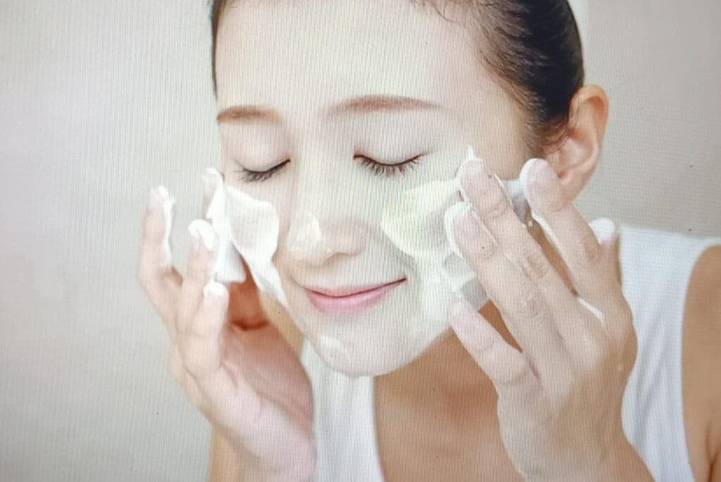 a woman cleansing her face