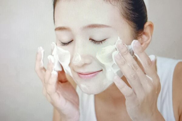 a woman cleansing her face 